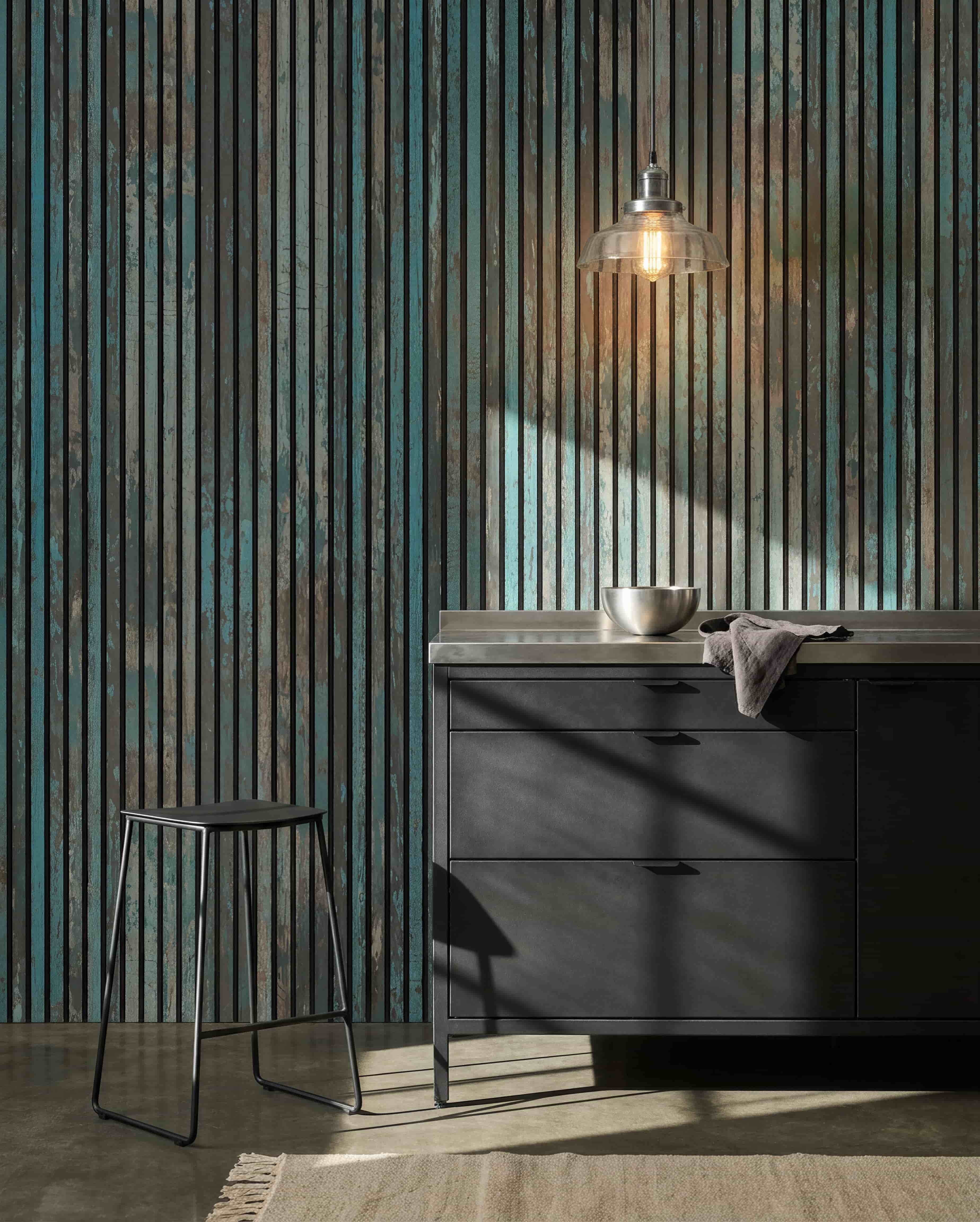 Modern kitchen with black stools, black cabinets, a bowl beneath a bulb light, and a WoodUpp Akupanel Oxide Blue acoustic panel on the wall for sound comfort.