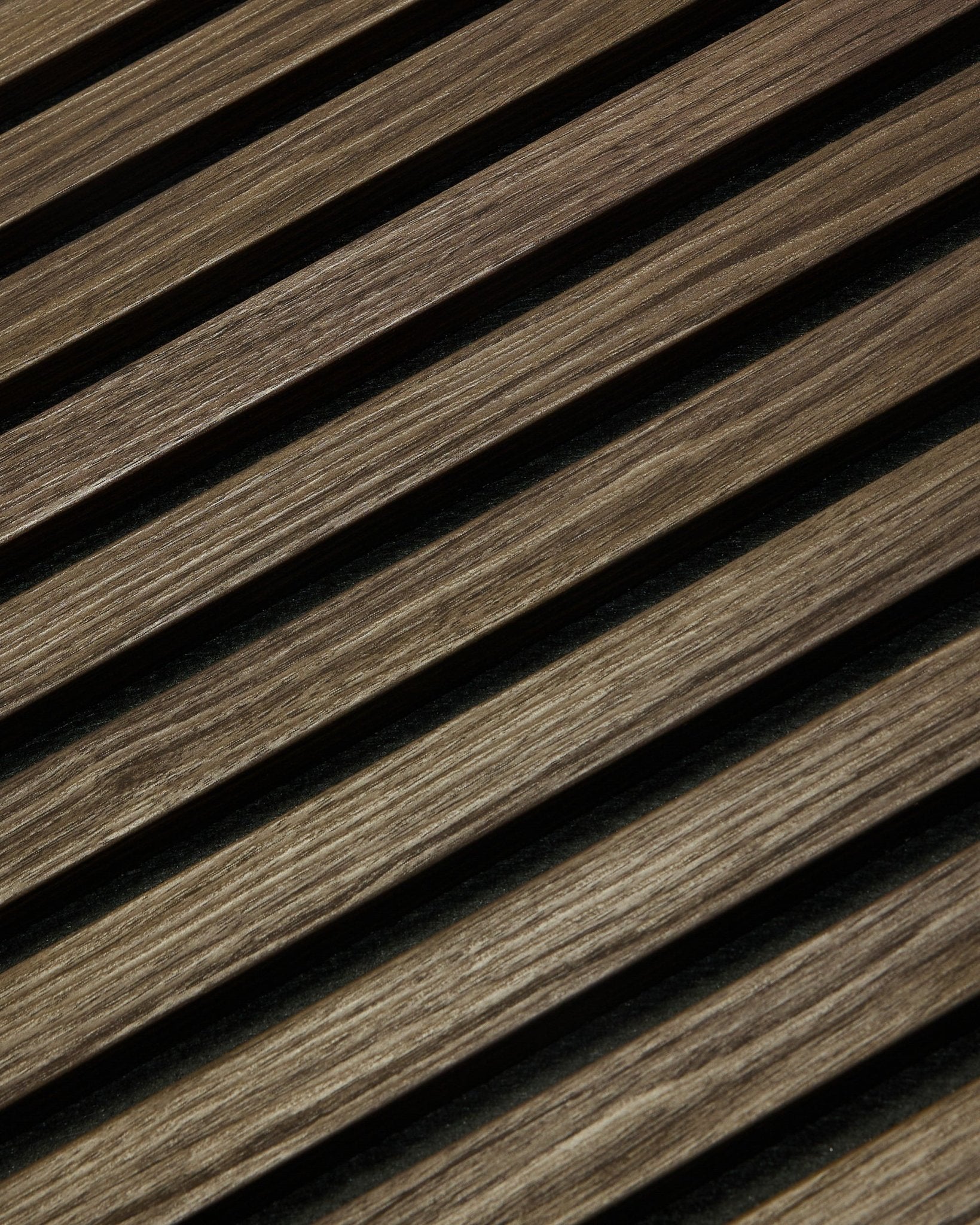 Close-up of WoodUpp Essential Akupanel in Black Oak, 240 x 60 cm, featuring diagonal wood slats with visible grain designed for acoustic improvement.
