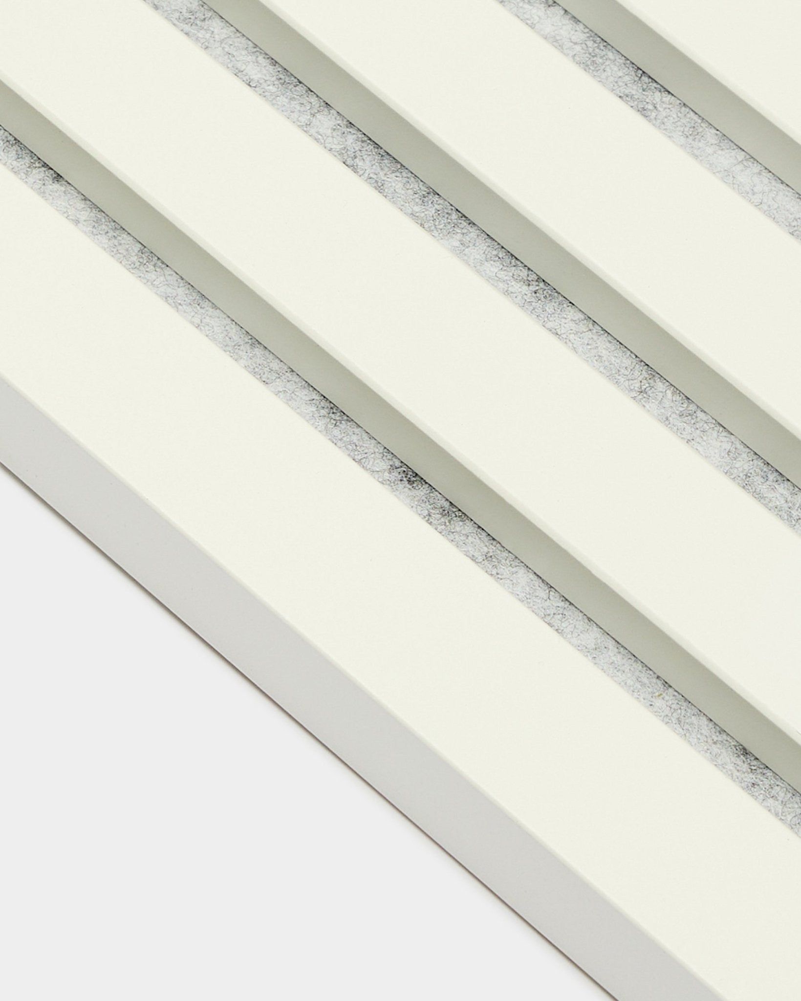 Four WoodUpp Akupanel End Lamella/Snow acoustic panels (2.2 cm) arranged diagonally, featuring off-white slats and textured gray gaps in a Nordic style.