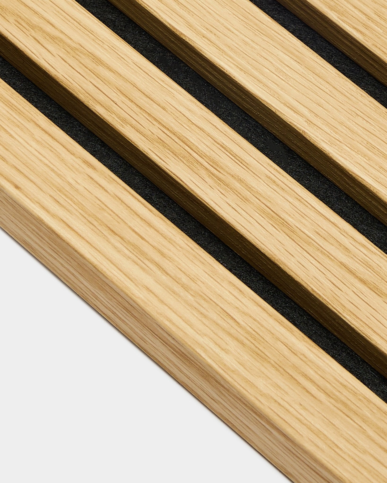 Close-up of WoodUpp Akupanel End lamella in Southern Oak, 2.2 cm wide slats with black gaps, arranged diagonally on a light grey background.
