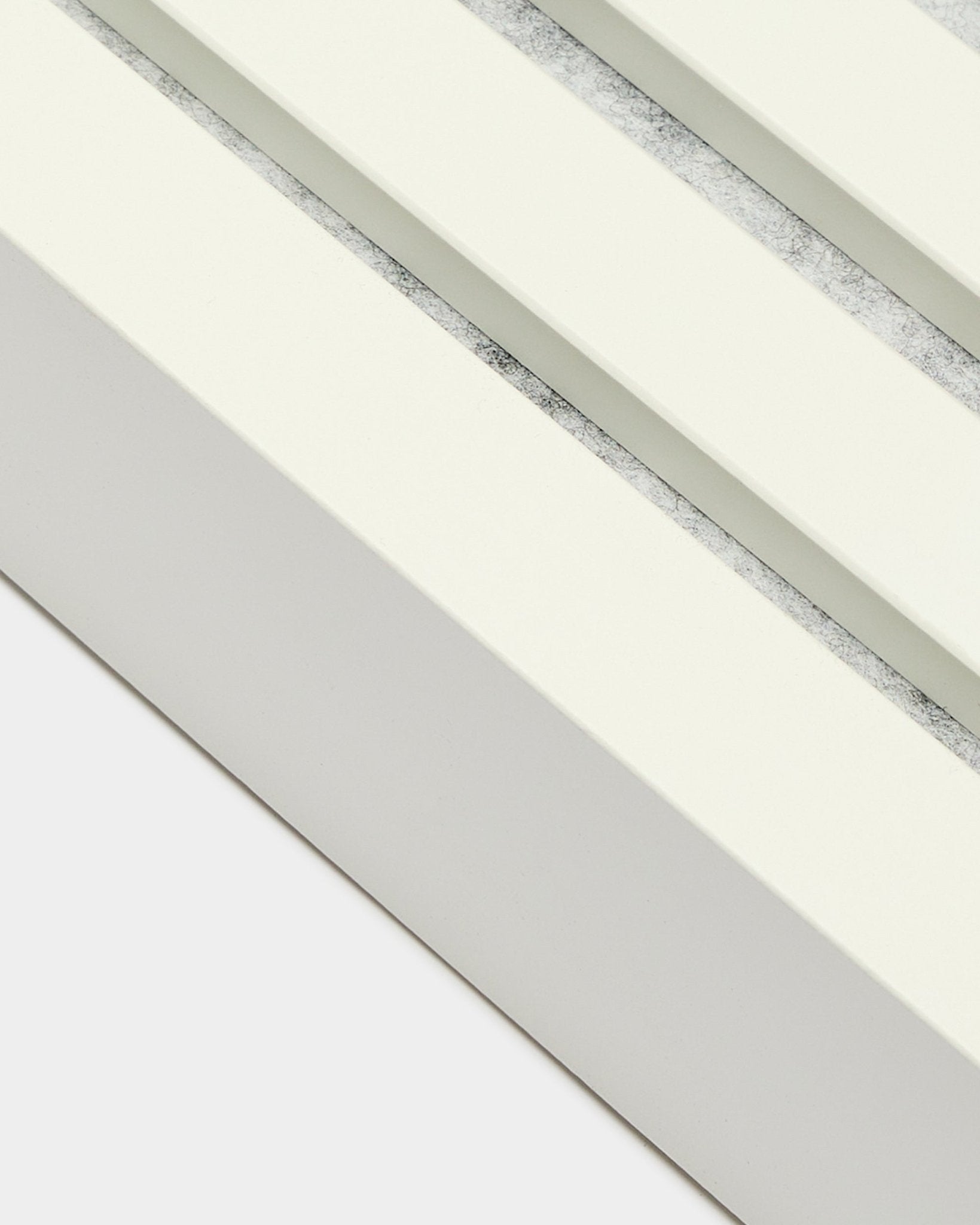 Close-up of WoodUpp End Lamella in Snow, 6.7 cm wide, with MDF frame, dual grooves, and a textured grey finish for Akupanel acoustic panel installation.