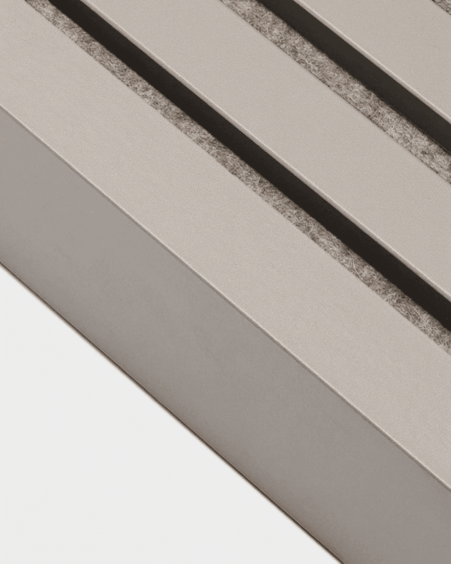 Close-up of WoodUpp Akupanel end lamella in Dark Cashmere, 240x6.7cm, with vent shadows cast on a beige MDF frame.