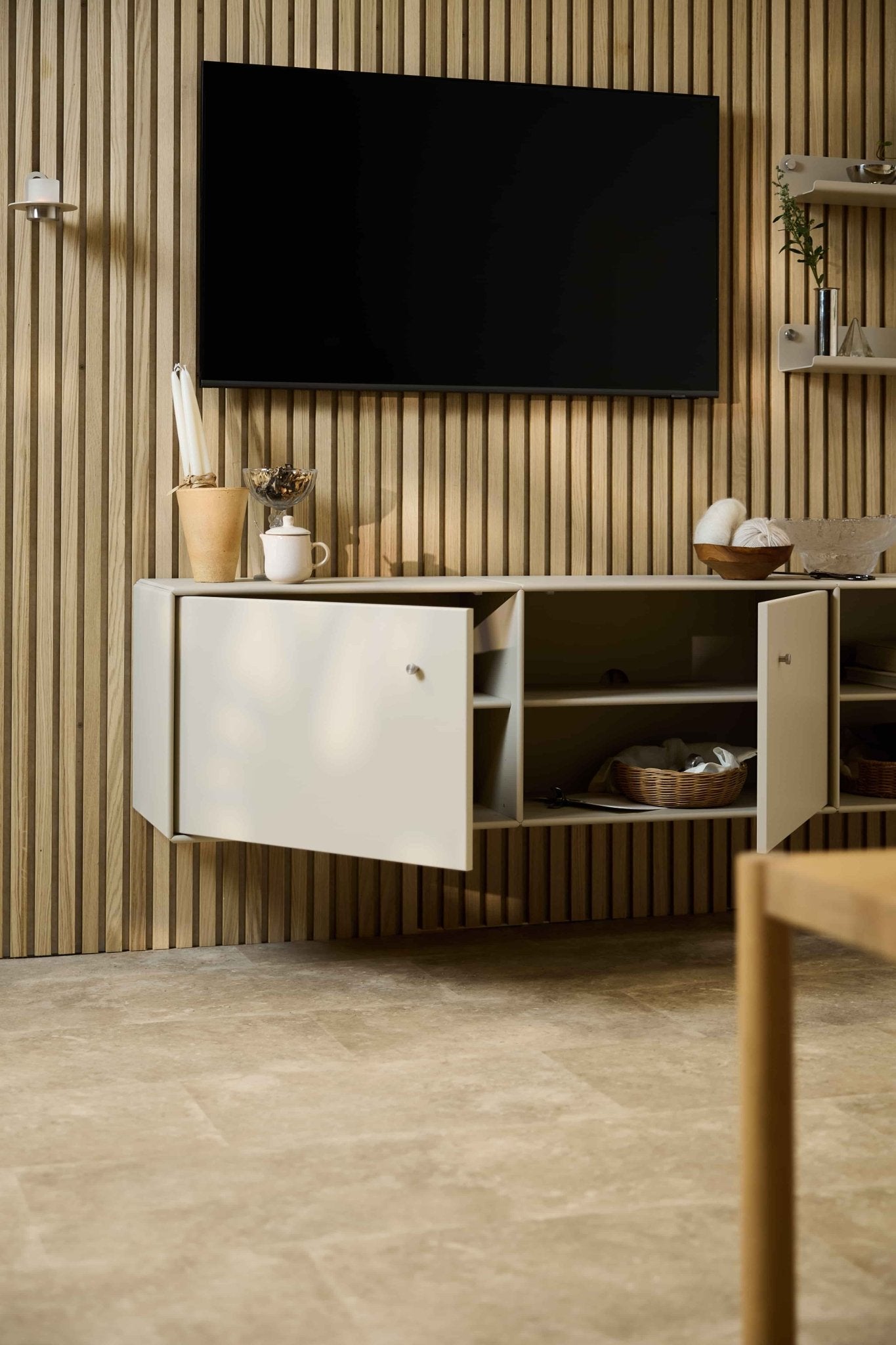 Modern living room featuring the Arka TV Console in Beige by WoodUpp beneath a cabinet and TV on a Nordic Akupanel acoustic wood slat wall. Modular furniture.