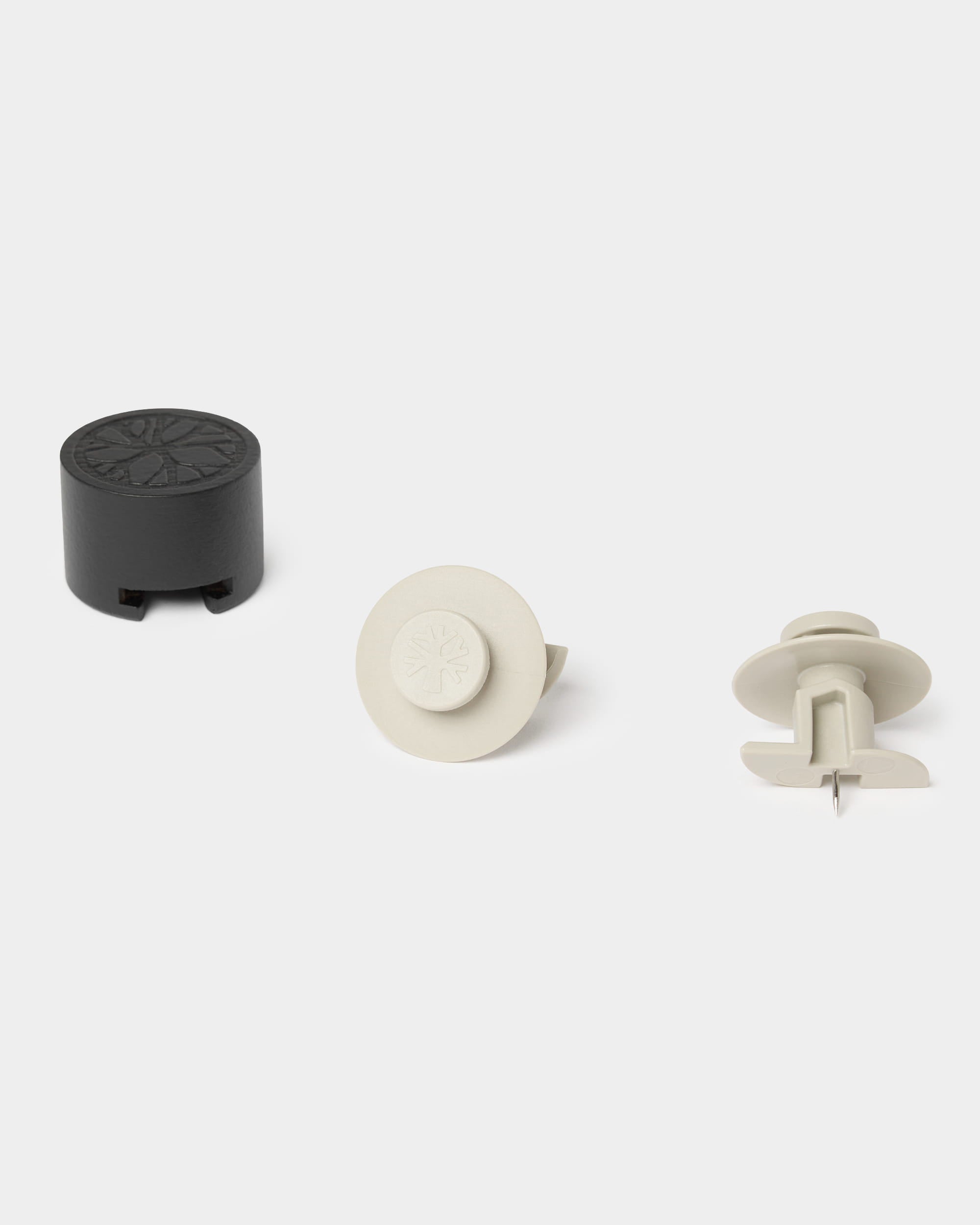 Seven beige Dupps hooks and one installation tool by WoodUpp arranged on a light surface, designed for mounting Akupanel acoustic wood panels.
