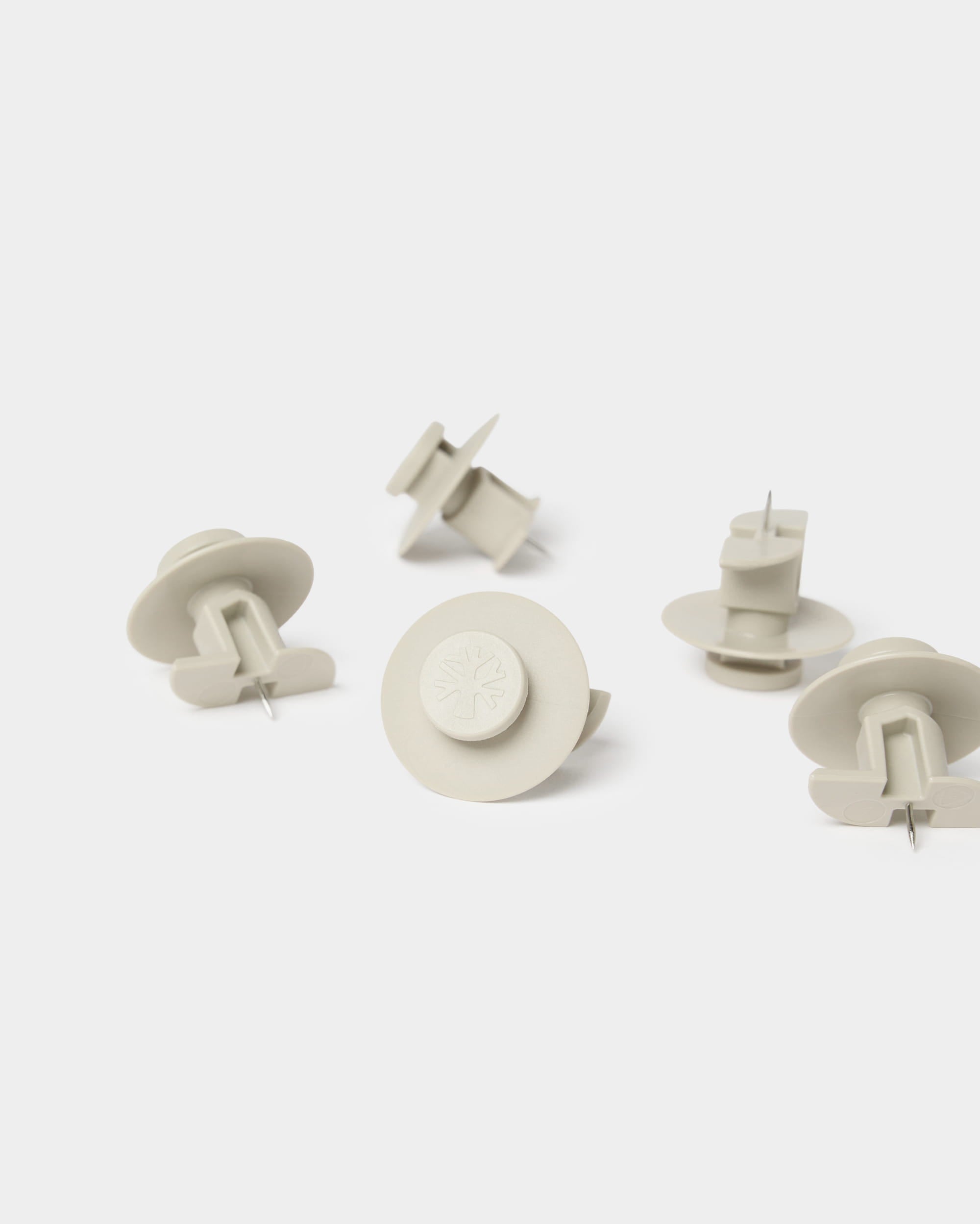 Seven beige WoodUpp Dupps push pins with tool included, designed for mounting Akupanel acoustic panels or other WoodUpp wall solutions.