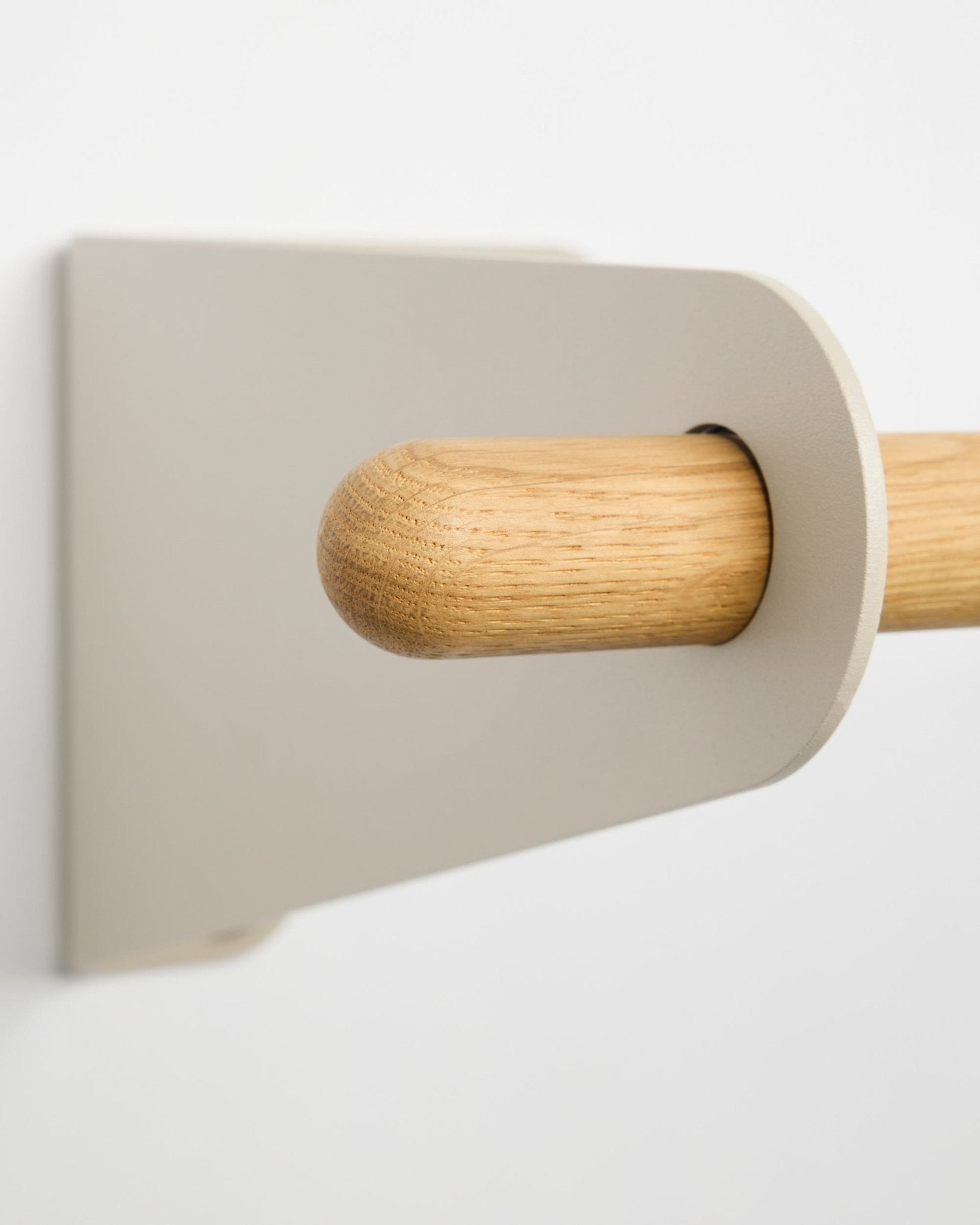 Close-up of the WoodUpp Linn Coat Rail in beige (75.9 cm), a solid oak rod with minimalist bracket, mounted on a white wall, showing Nordic design.