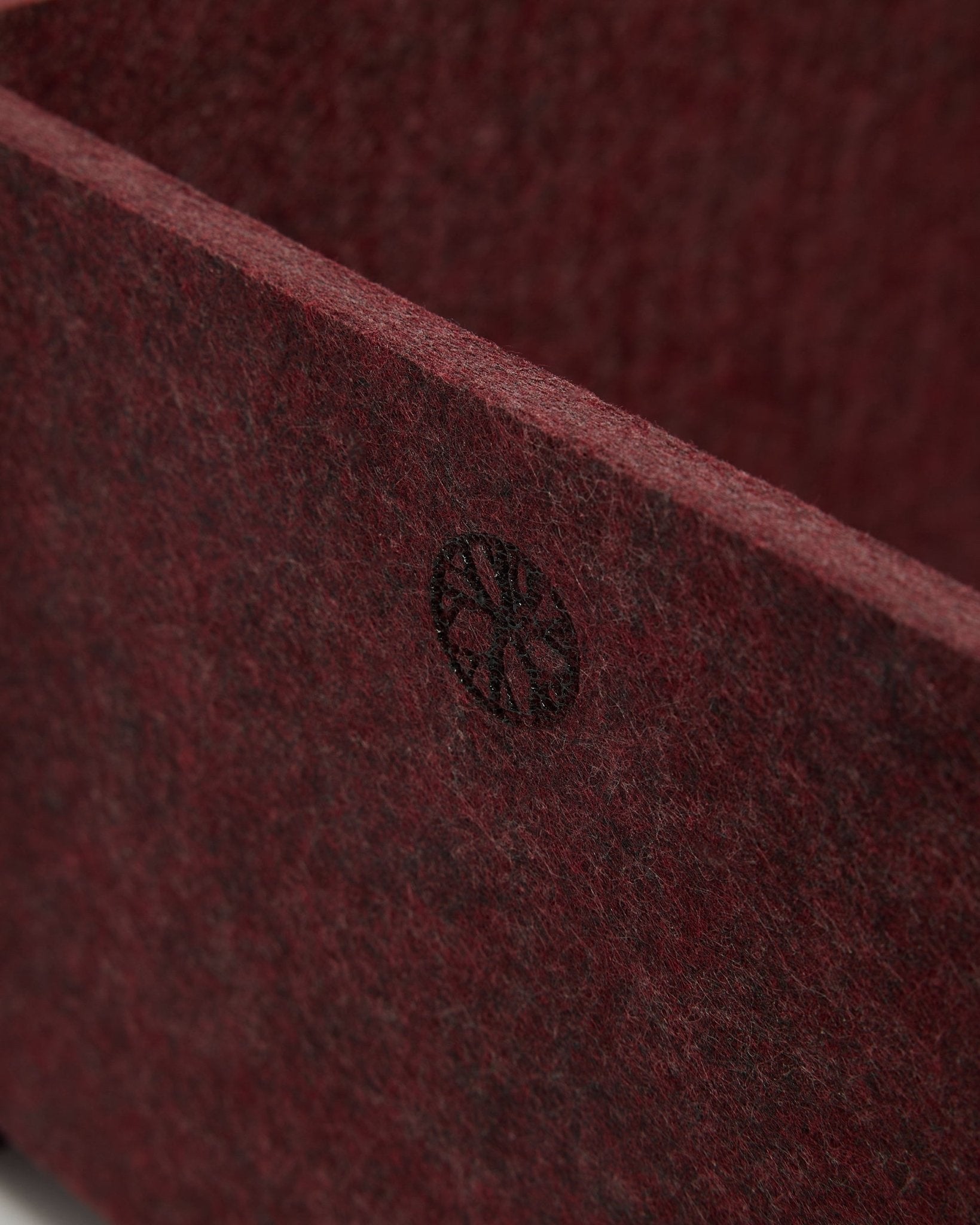 Close-up of WoodUpp Vigg | Felt Box / BM2 in ox red, showing textured PET felt and a circular black emblem in the corner. Nordic acoustic accessory design.