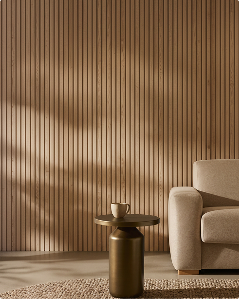 Minimalist living room with a beige armchair, woven rug, and round side table, featuring a vertical Akupanel acoustic wood slat wall in soft natural light.