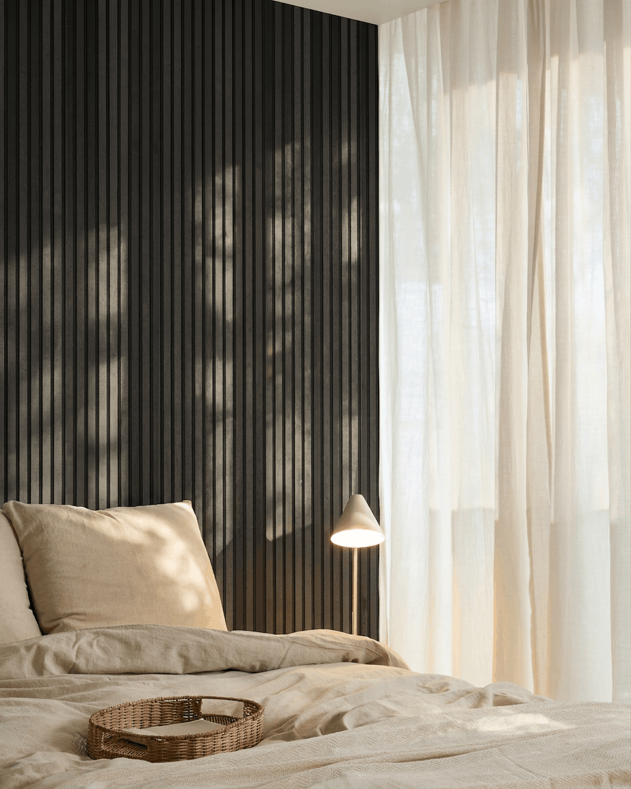 Minimalist Nordic bedroom featuring a WoodUpp Akupanel acoustic panel in Black Ash, beige bedding, a wicker tray, and sheer curtains allowing natural light.